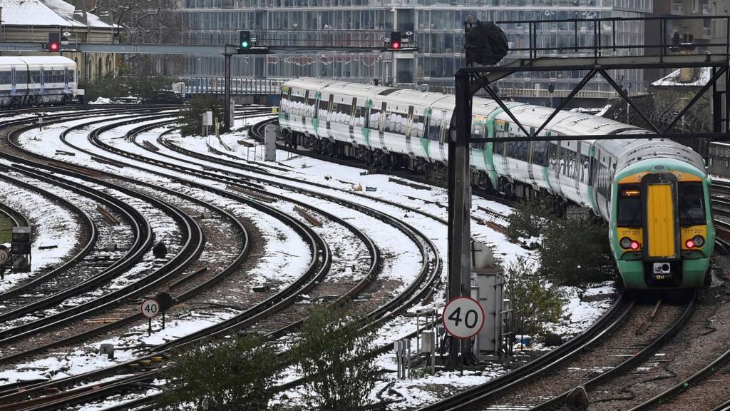 A train approaches Victoria station along snow-covered tracks