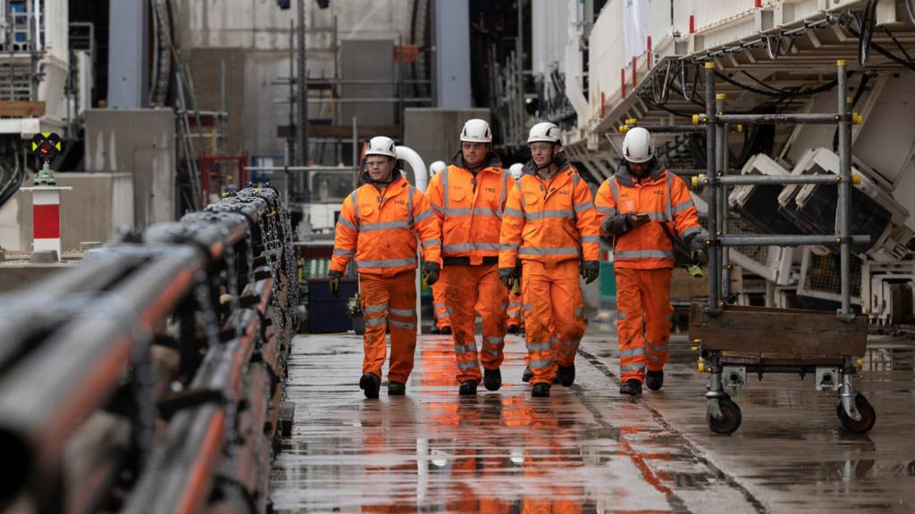 Workmen walk from the tunnel at an HS2 construction site