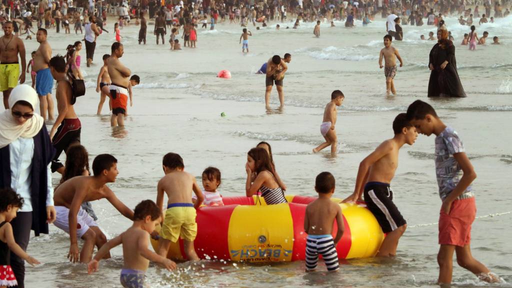 Libyans hang out at the beach in the capital Tripoli on 14 July 2016