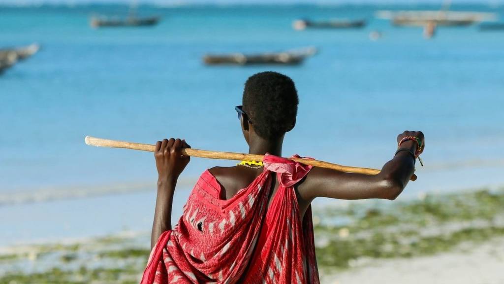 A Maasai tribesman stands on ocean coast in Zanzibar, Tanzania on August 20, 2018.