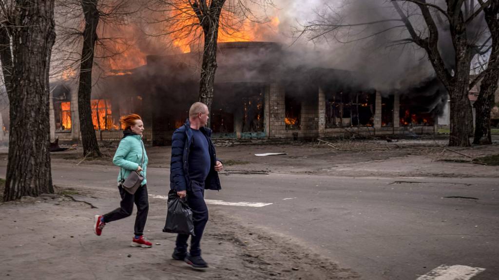 Residents run near a burning house following a shelling Severodonetsk, Donbass region, on April 6, 2022.