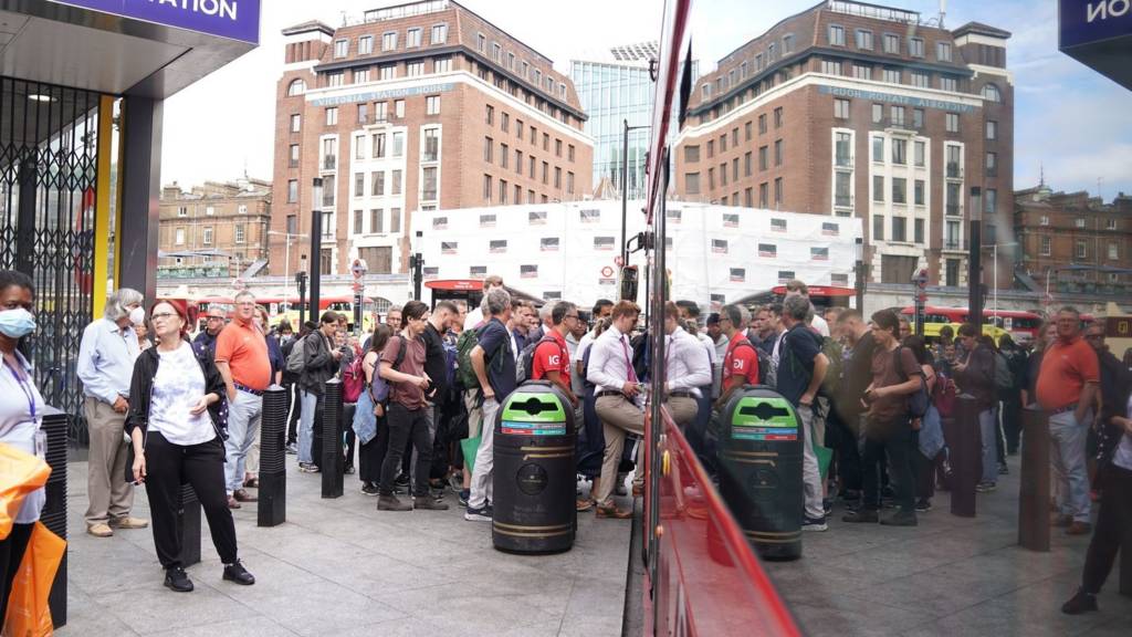 People waiting for a bus outside London's Victoria Station.