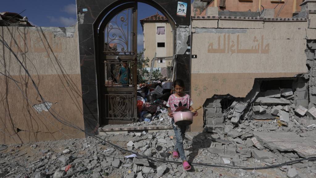 A Palestinian child carries usable items, found among the debris of destroyed building following the Israeli attacks on the al-Salam Neighborhood in Rafah, Gaza on May 5, 2024