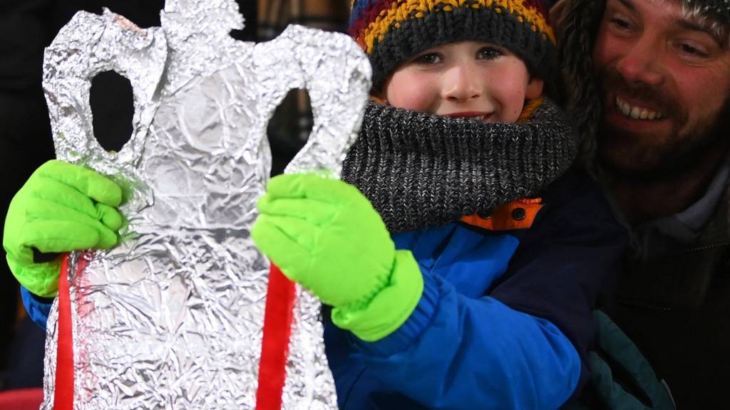 A young fan holding up a cardboard cut-out of the FA Cup