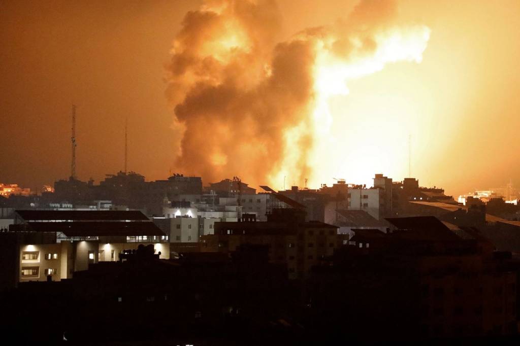 Fire and smoke rises above buildings during an Israeli air strike in Gaza City on 8 October 2023