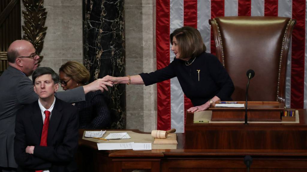 Nancy Pelosi shakes hands with another Democrat