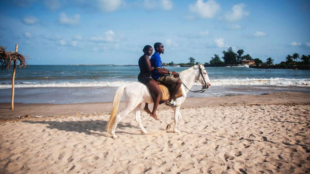 People riding a horse on a beach in Lagos, Nigeria