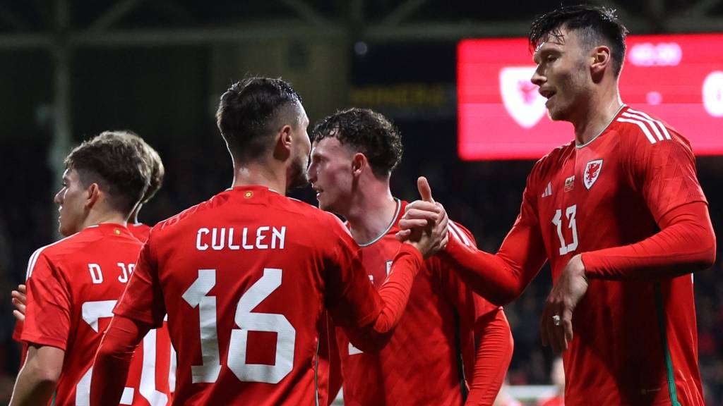 Wales players celebrate with Kieffer Moore
