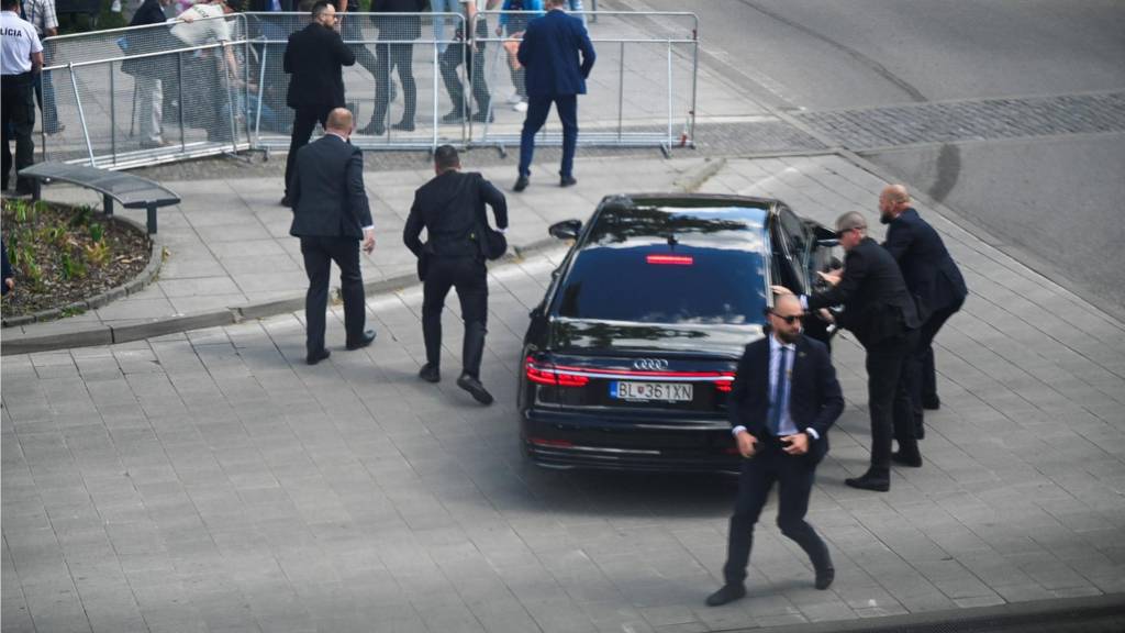 Security officers move Slovak PM Robert Fico in a car after a shooting incident, after a Slovak government meeting in Handlova,