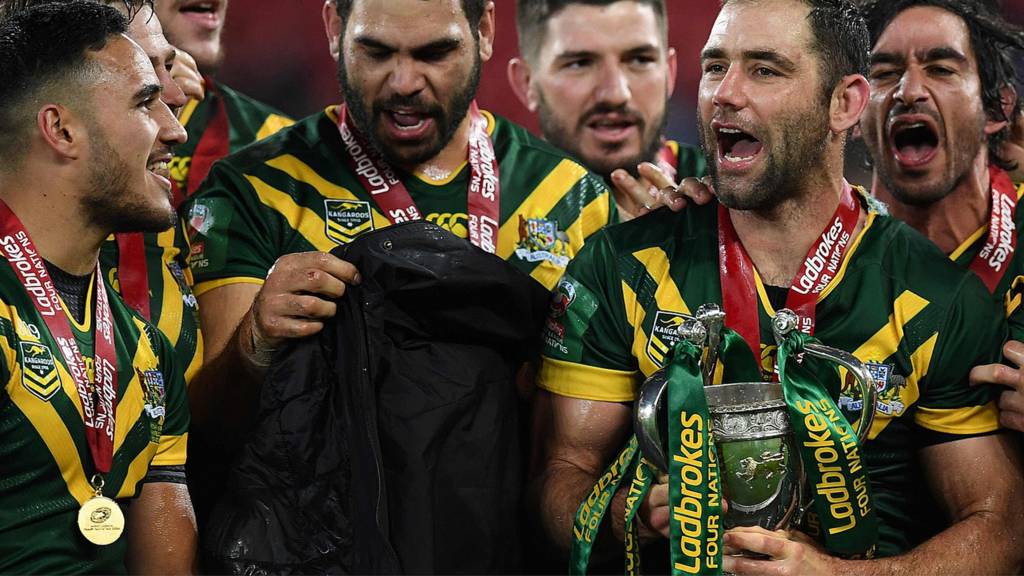 Cameron Smith (C) holds the trophy