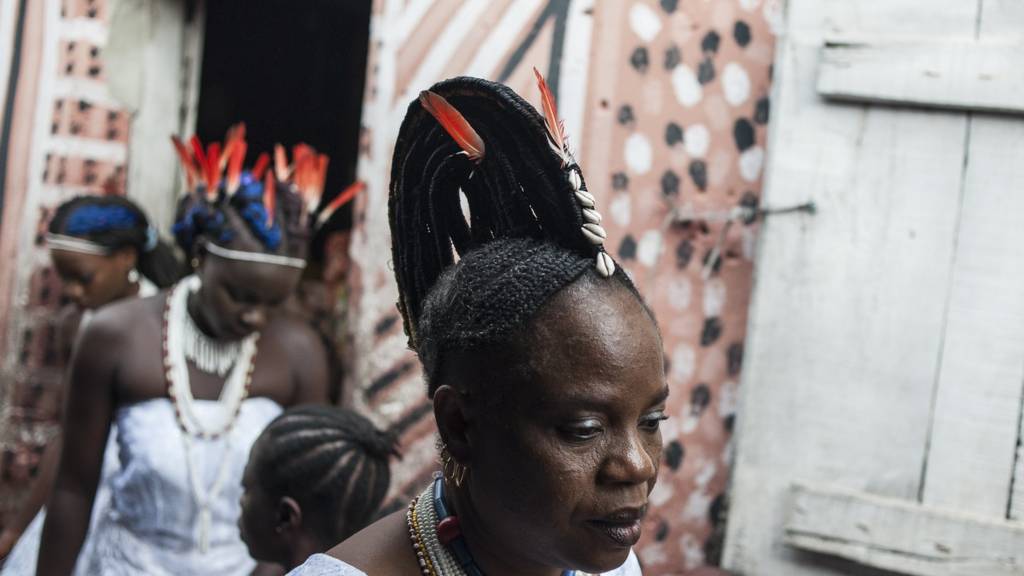 Devotees leave the river goddess Osun shrine after attending a prayer session during the Osun-Osogbo Festival in Osogbo, Nigeria