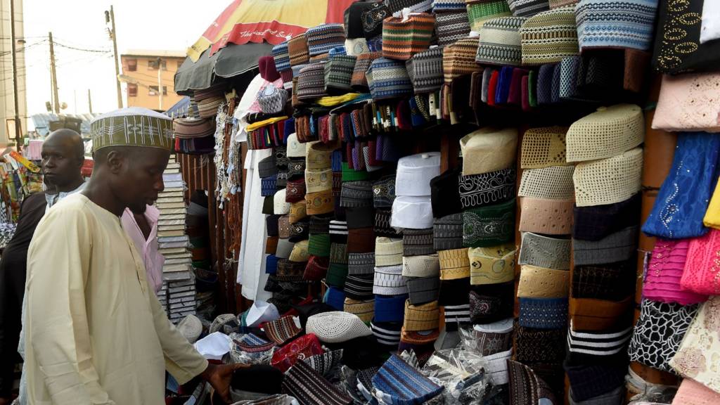 A man looks at various Taqiyah caps on sale in Lagos, on 26, 2017, as Muslims begin with preparations to mark the holy fasting month of Ramadan