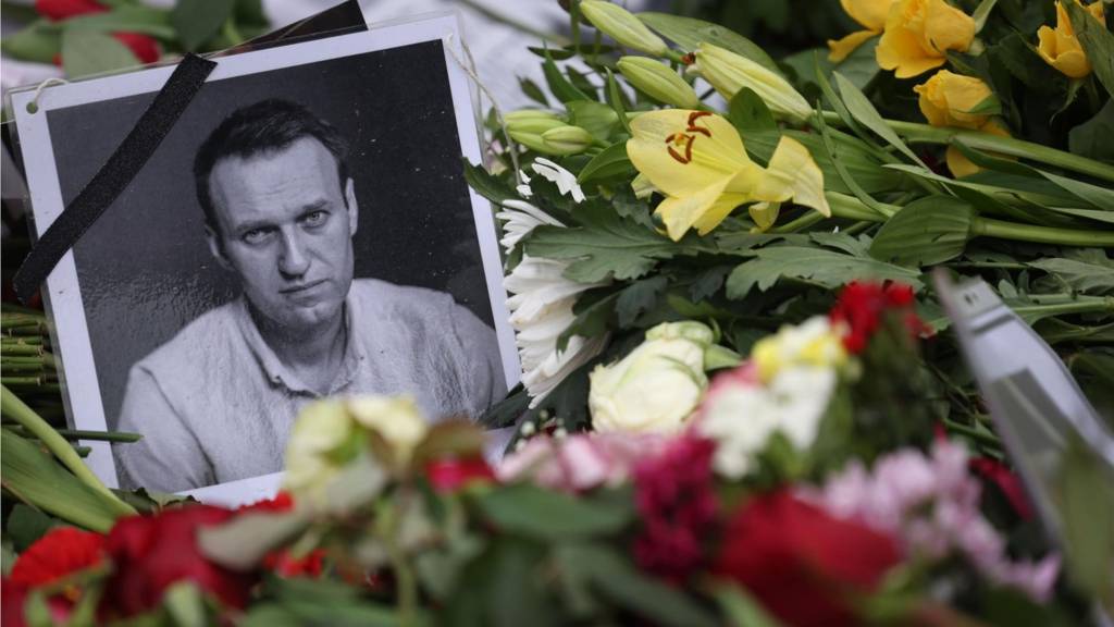 A portrait of deceased Alexei Navalny is positioned between flowers during a rally in Berlin