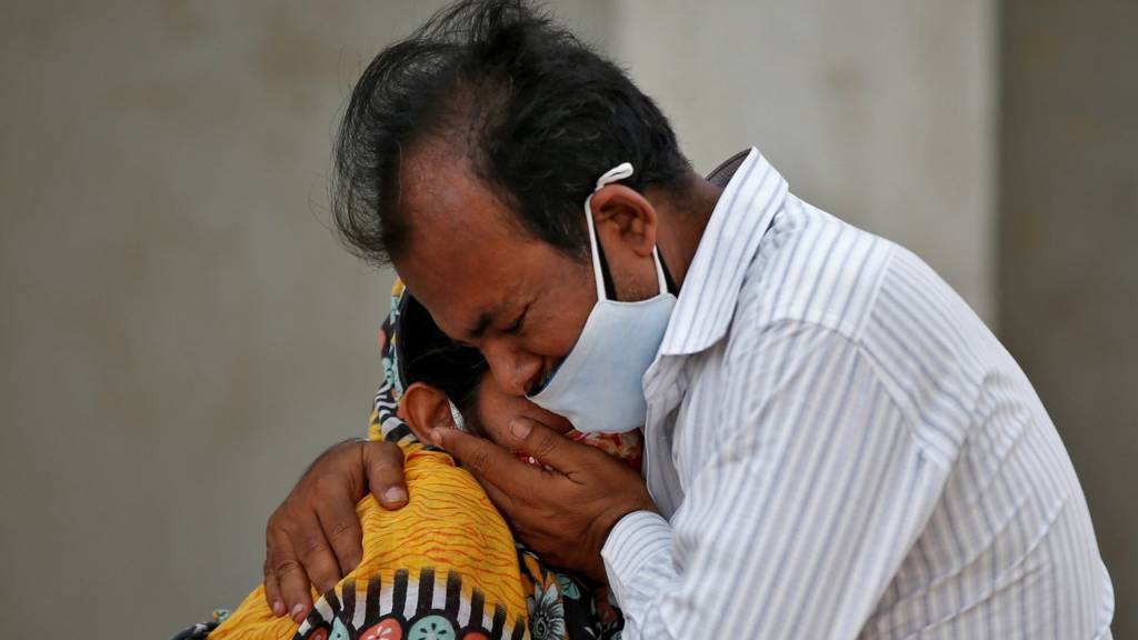 A man comforts a woman in India