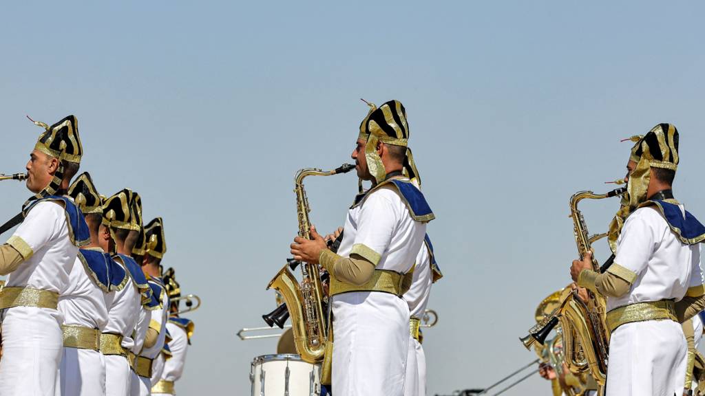 Marching band members dressed in ancient Egyptian clothing perform ahead of the Pyramids Air Show 2022 at the Giza Pyramids Necropolis on the southwestern outskirts of the Egyptian capital on August 3, 2022.