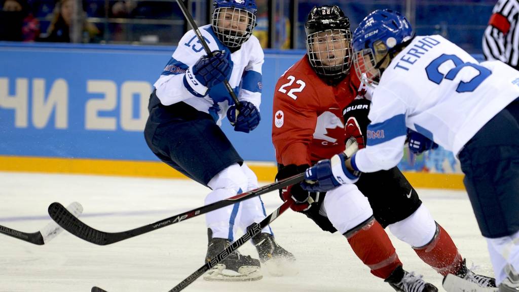 Canada's Hayley Wickenheiser vies with Finland's Emma Terho and Minnamari Tuominen