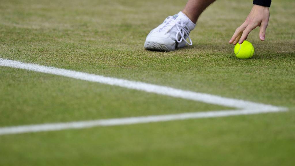 A ball boy retrieves a tennis ball at the Wimbledon Championships