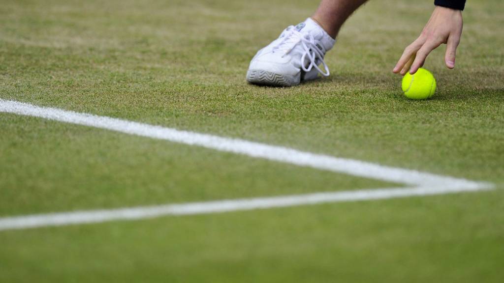 A ball boy retrieves a tennis ball at the Wimbledon Championships