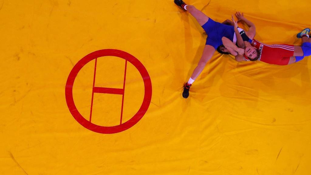 England's Yana Rattigan (blue) is thrown by India's Vinesh