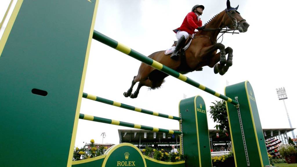 A rider jumps a fence at a showjumping event