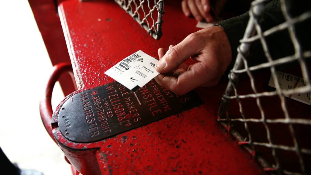 A fan hands over a ticket