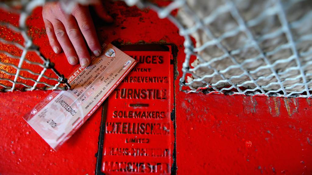 A fan hands over a ticket