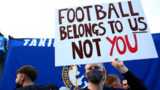A fan protests with a sign saying 'football belongs to us, not you'