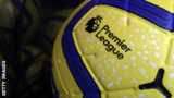 The Premier League logo on a yellow and blue football