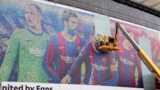 A picture of Lionel Messi is taken down outside the Nou Camp