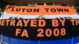 Luton Town fans display a banner