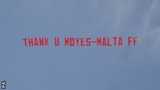 A plane flys over Old Trafford with a 'Thank you Moyes' banner