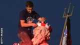 Atletico Madrid captain Gabi puts a scarf around the head of the statue of Neptune