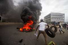 Protesters making a fire on road in Luanda on Saturday