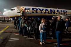 Passengers wait to board an aircraft of low-cost Irish airline Ryanair at Bergamo airport, Italy