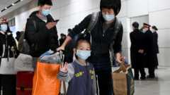 Family arriving in Wuhan, with small child waving