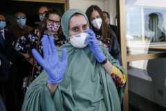 Silvia Romano, wearing a green tunic, waves upon her arrival at the Ciampino airport, Rome, Italy
