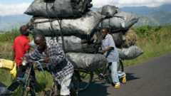 Les gens dans l'est de la RD du Congo avec des vélos chargés de charbon de bois