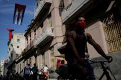 A man in a facemask cycles through Havana, Cuba