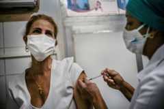 A nurse applies a dose of the Soberana-02 COVID-19 vaccine to a health worker