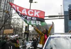 Woman with a flag reading "Black Lives Matter"
