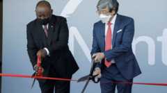 South African President Cyril Ramaphosa (L) and founder of NantWorks Dr Patrick Soon-Shiong (R) cut a ribbon using giant scissors during the inauguration of the Nant-SA Vaccine Production Facility in Cape Town, South Africa, 19 January 2022