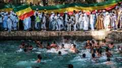 Ethiopian Orthodox worshippers at the compound of Fasilides Bath during the celebration of Timket, the Ethiopian Epiphany, in the city of Gondar, Ethiopia – 19 January 2022