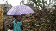 Two children look at a collapsed house in Madagascar
