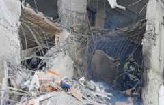 Firefighters put out flames inside a bombed apartment block in Kyiv