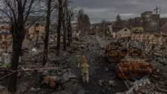 Μέλη του ουκρανικού στρατού περνούν δίπλα από κατεστραμμένα ρωσικά στρατιωτικά μηχανήματα στο δρόμο, στην Μπούχα, την πόλη που ανακαταλήφθηκε από τον ουκρανικό στρατό, βορειοδυτικά του Κιέβου