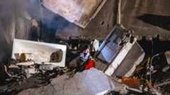 На снимке: женщина на развалинах разрушенной многоэтажки в Днепре