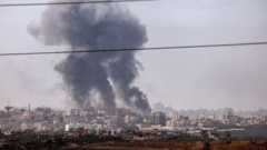 A plume of smoke hanging above buildings in the Gaza Strip