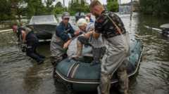 Δύο άνδρες βοηθούν μια ηλικιωμένη γυναίκα να βγει από μια φουσκωτή βάρκα.
