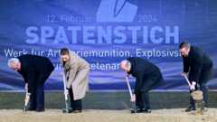 Четыре человека с лопатами и кучей песка