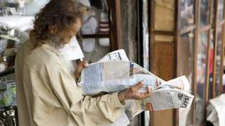 man reading newspaper in Port Louis